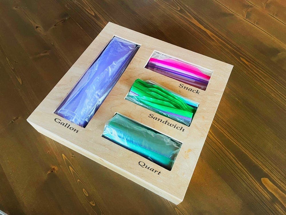 A small divided box organizer for storing bag boxes with pull-through cutouts on top