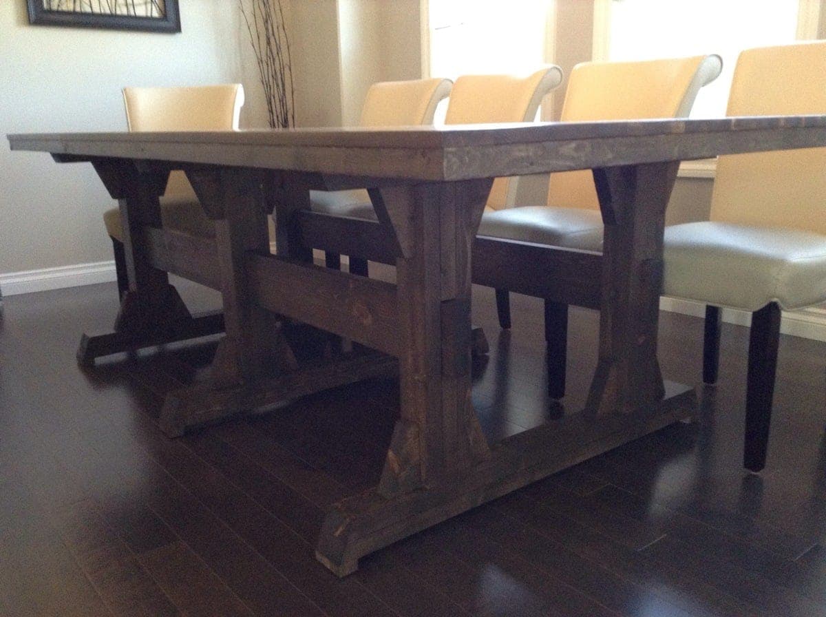 Extra-wide farmhouse dining table on three boxed pedestal legs with angled cross supports