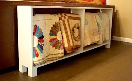 Narrow console table with a dowel quilt rack hung underneath the top