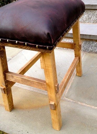 Bar-height stool with splayed legs and a nailhead-trimmed upholstered seat