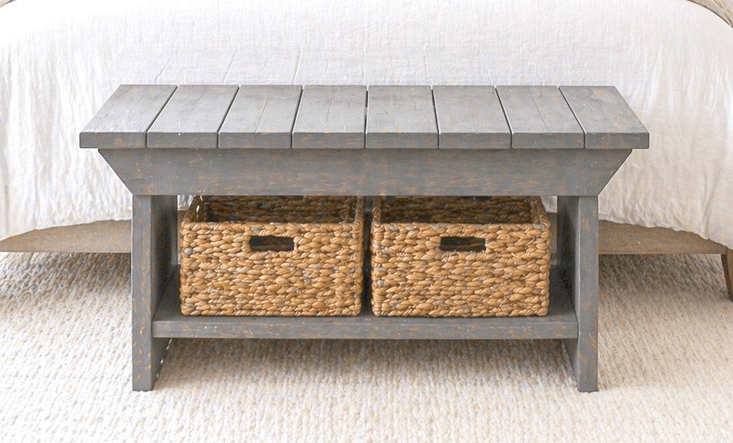 A small bench with a slatted top, a lower shelf, and shaped legs