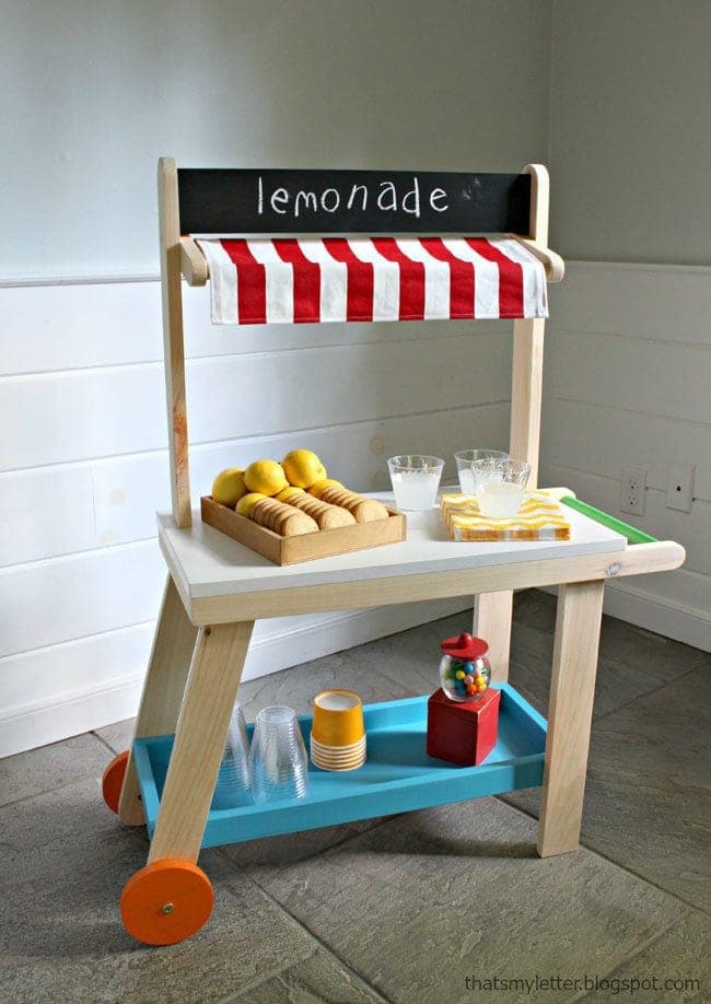 Kid-sized wooden lemonade cart with wheels and an awning sign