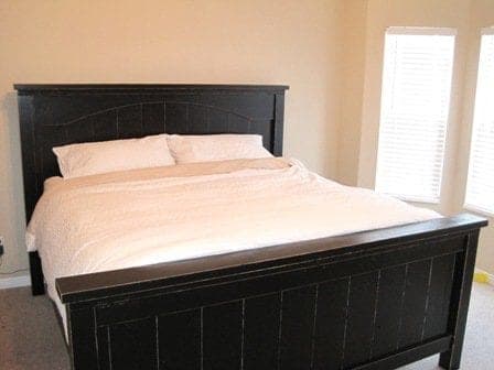 Planked farmhouse bed with an arched headboard on chunky 4x4 posts