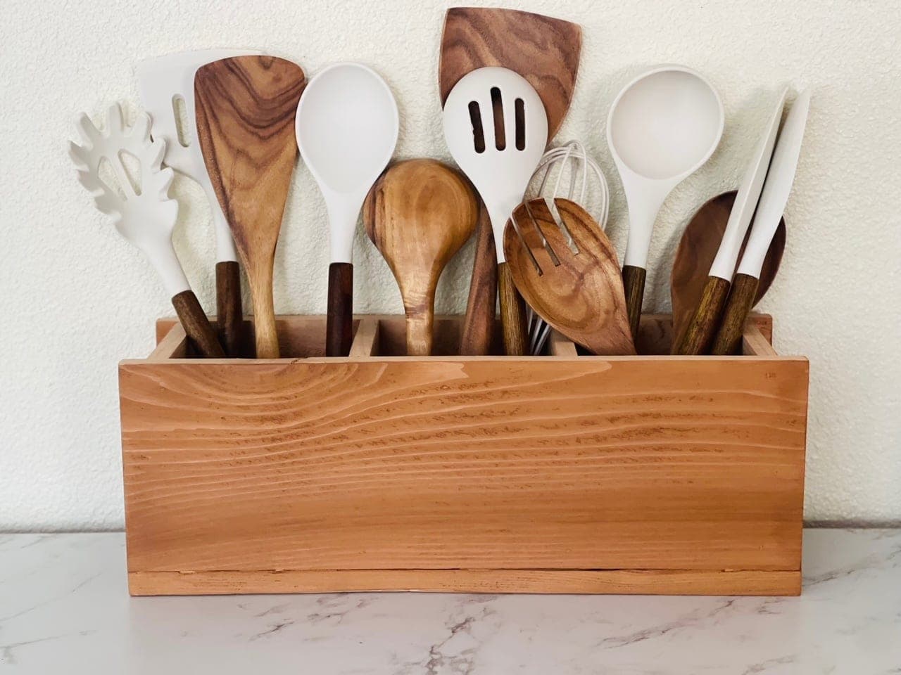 Divided wooden caddy holding utensils and napkins