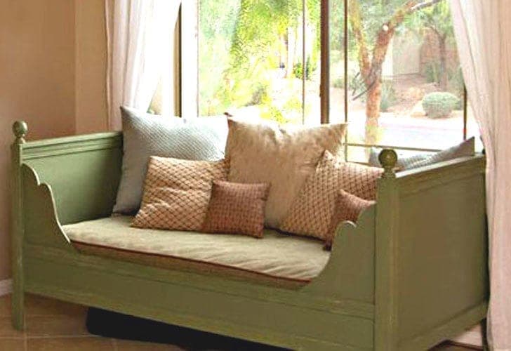 A moulding-trimmed daybed with tapered legs and scalloped side panels