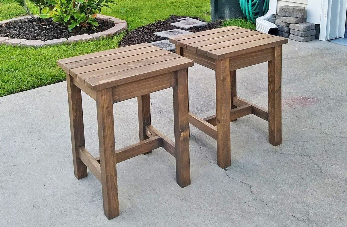 Small square wood stool with slatted top, used as an outdoor end table