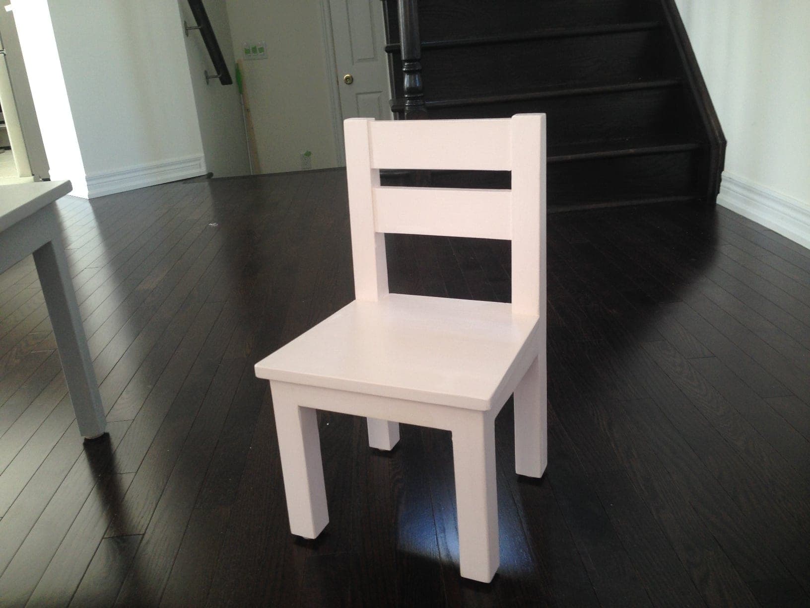 Small wooden kids chair with tapered back legs and a shaped seat