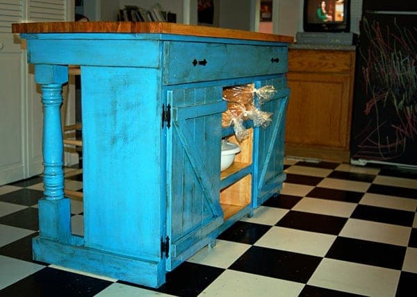 Farmhouse kitchen island with slatted doors and a butcher block top