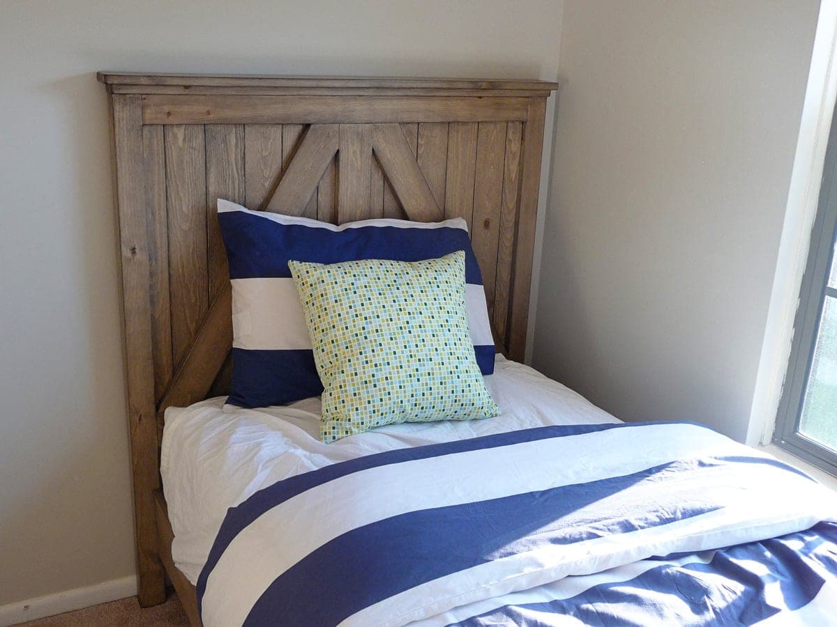 Rustic planked farmhouse headboard for a twin bed with an angled cross-brace