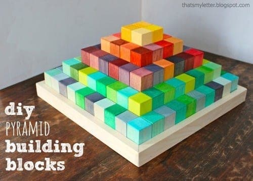 Stacking wood block pyramid toy with graduated block sizes and a fitted storage tray