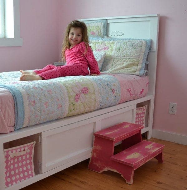 Twin storage bed built on cubby benches with a paneled headboard