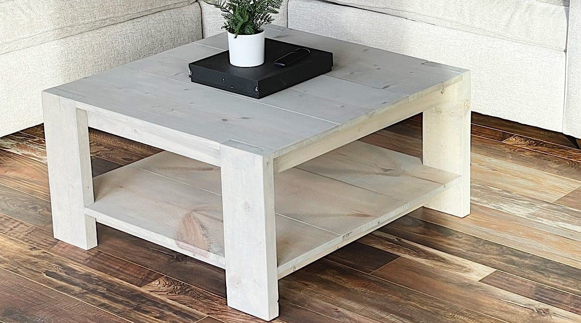 Square coffee table with chunky 2x6 legs poking through notched corners and a lower shelf
