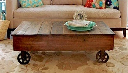 Low factory-cart-style coffee table on large caster wheels