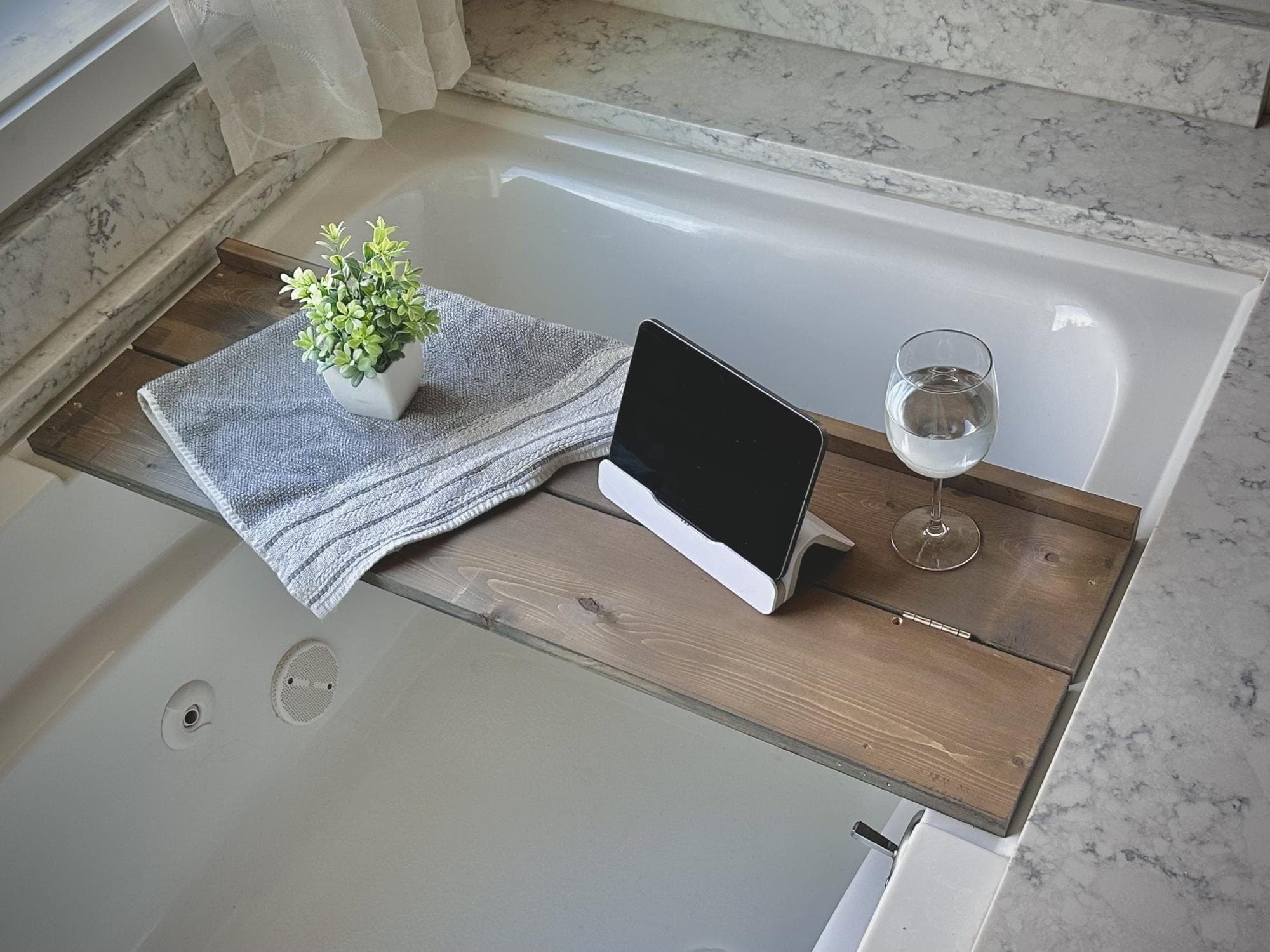 A wooden bath tray spanning a bathtub, folded from two hinged boards