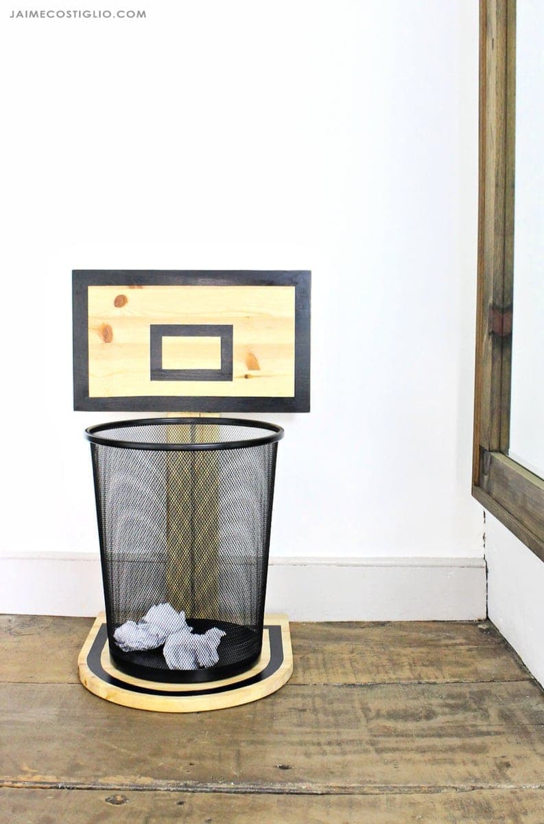 Small wooden basketball hoop backboard mounted over a trash can