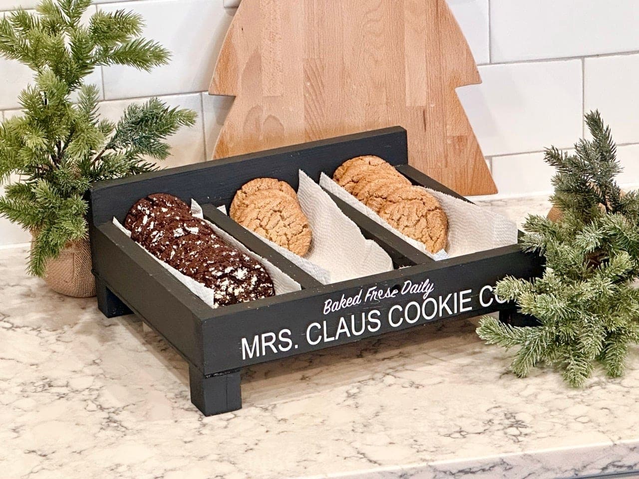 Shallow wooden cookie serving box on small feet with a lettered back board