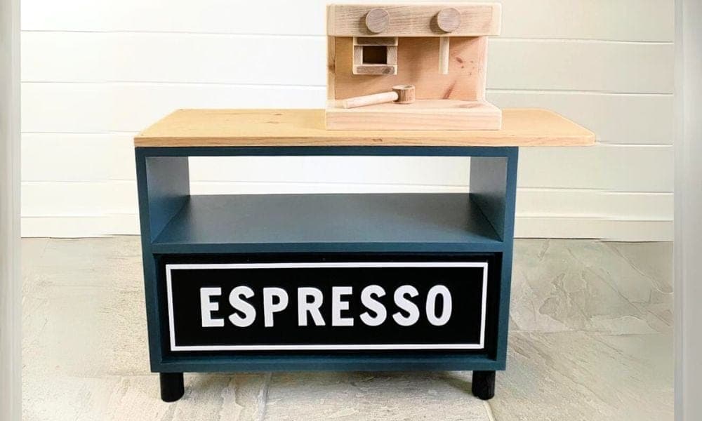 A children's pretend-play coffee cart with a wooden toy espresso machine