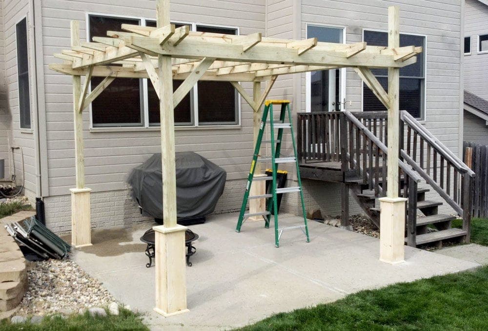 Backyard pergola with clad posts and a double-layer roof grid