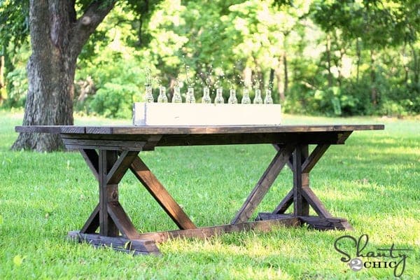 Farmhouse dining table with dramatic layered X-shaped leg ends and plank top