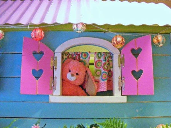 Decorative arched window shutters with heart cutouts above matching angled flower boxes
