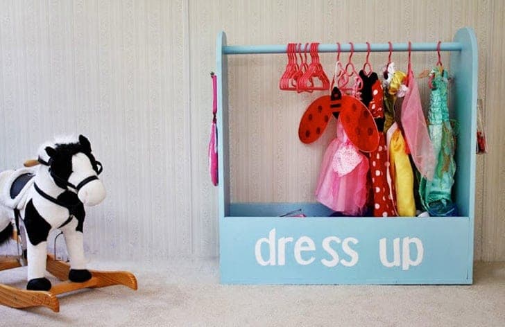 Kids' rolling dress-up storage with a hanging rod and arched sides over an open box