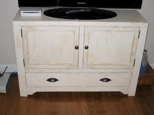 Rustic wooden media console cabinet with a lower drawer and beadboard back