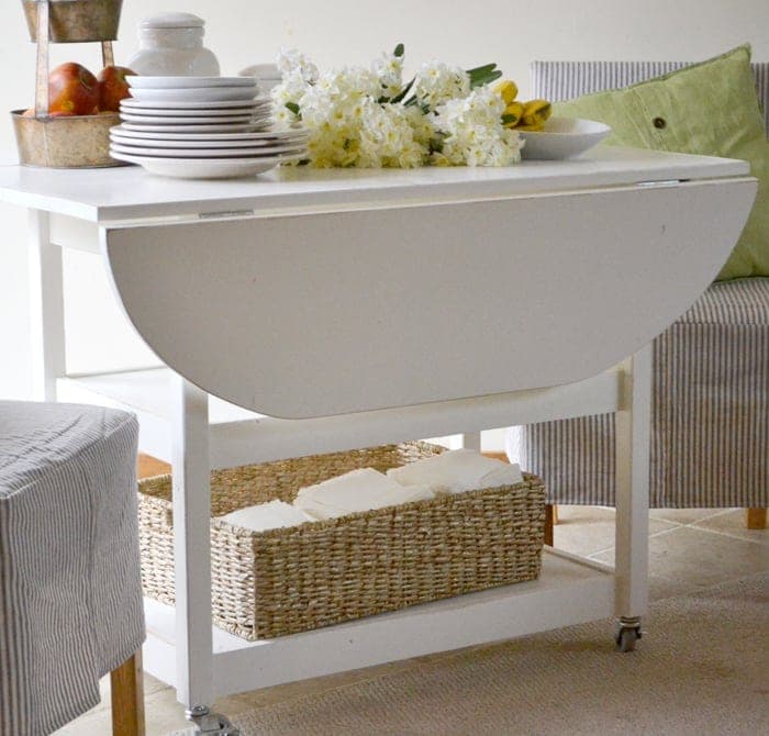 Rolling storage table with two drop leaves that form a round top