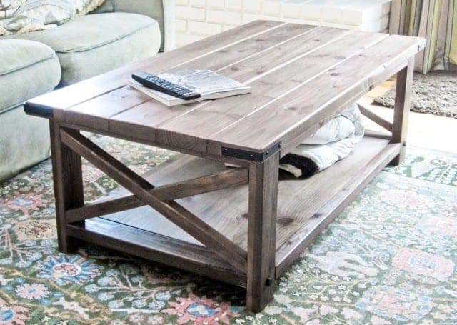Rustic coffee table with X-brace ends, plank top, and bottom shelf