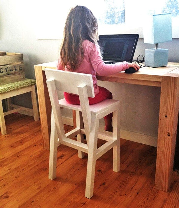 Wooden toddler high chair with splayed legs and a solid backrest