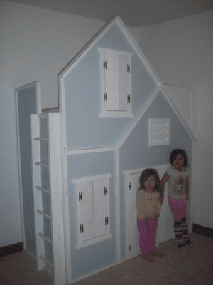 Full-height loft bed enclosed as a playhouse with windows and a door