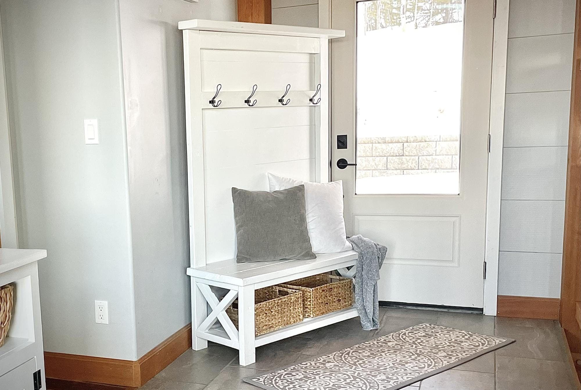 Rustic entryway hall tree bench with X-braced back and coat hooks
