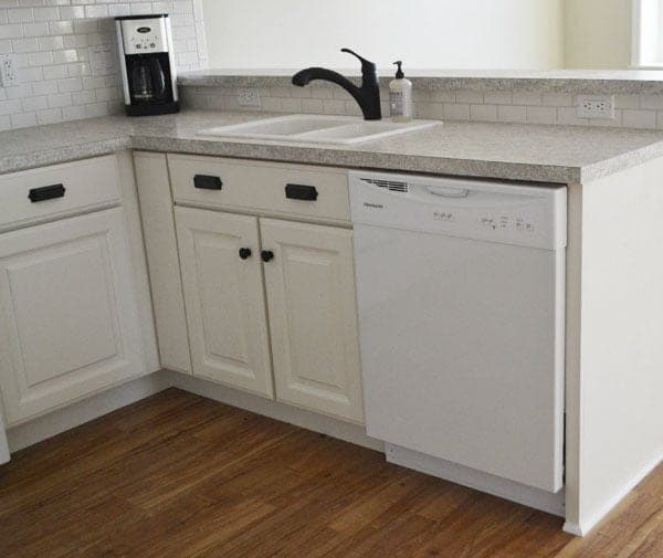 Fitted kitchen sink base cabinet with a face frame, doors, and open plumbing clearance behind