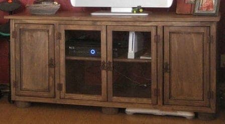 Wide rustic media console with four glass and mirror doors and bun feet