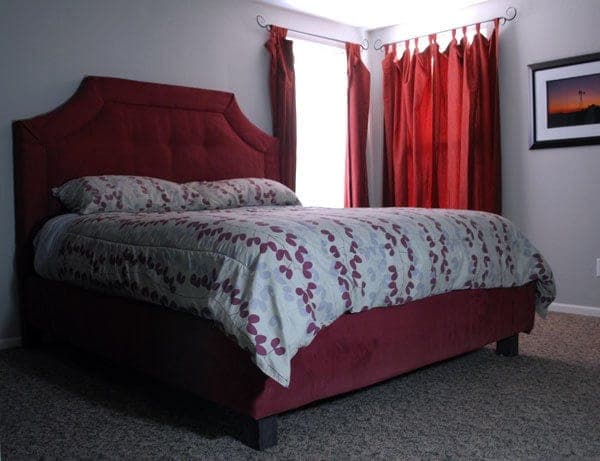 Upholstered platform bed with a button-tufted headboard panel