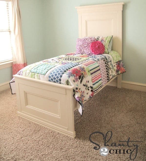 Twin bed with a tall crown-moulded headboard and matching footboard