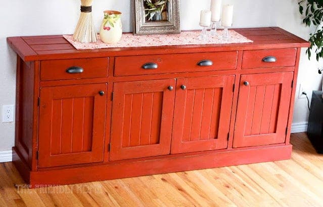 Planked wood sideboard with three drawers and two paneled doors