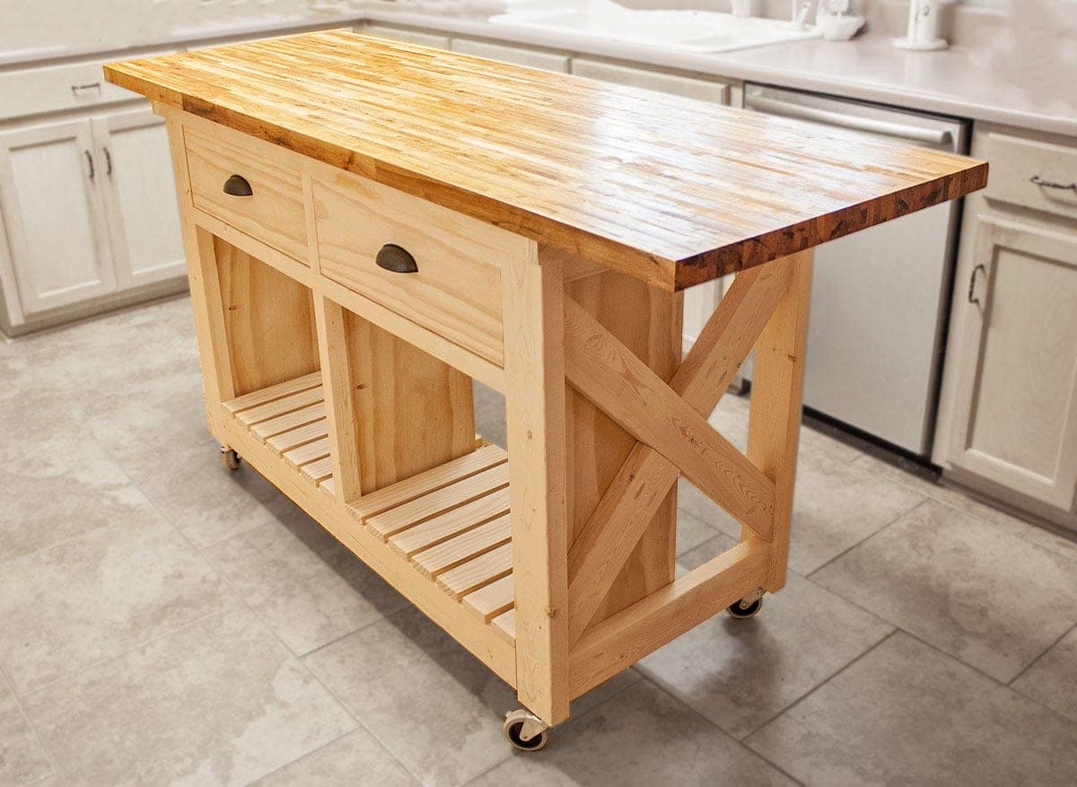 Rolling rustic kitchen island with X-braced ends, drawers, and slatted shelf