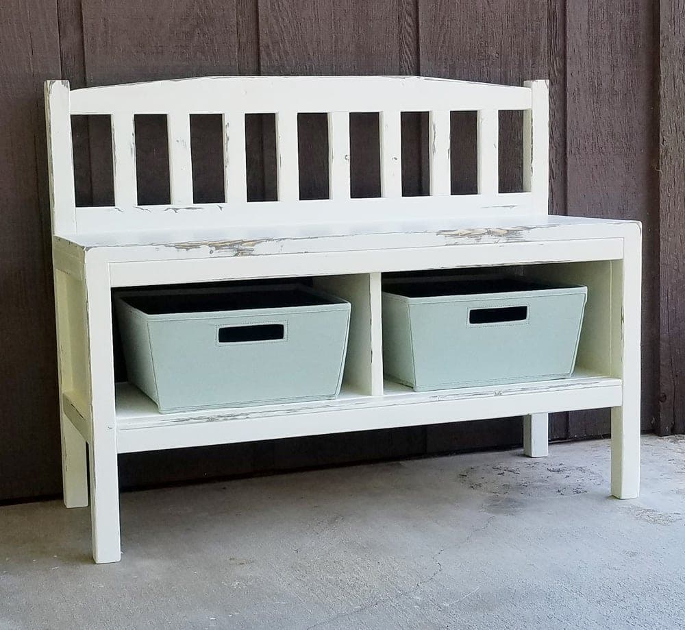 An entryway bench with a slatted back and two open storage cubbies underneath the seat