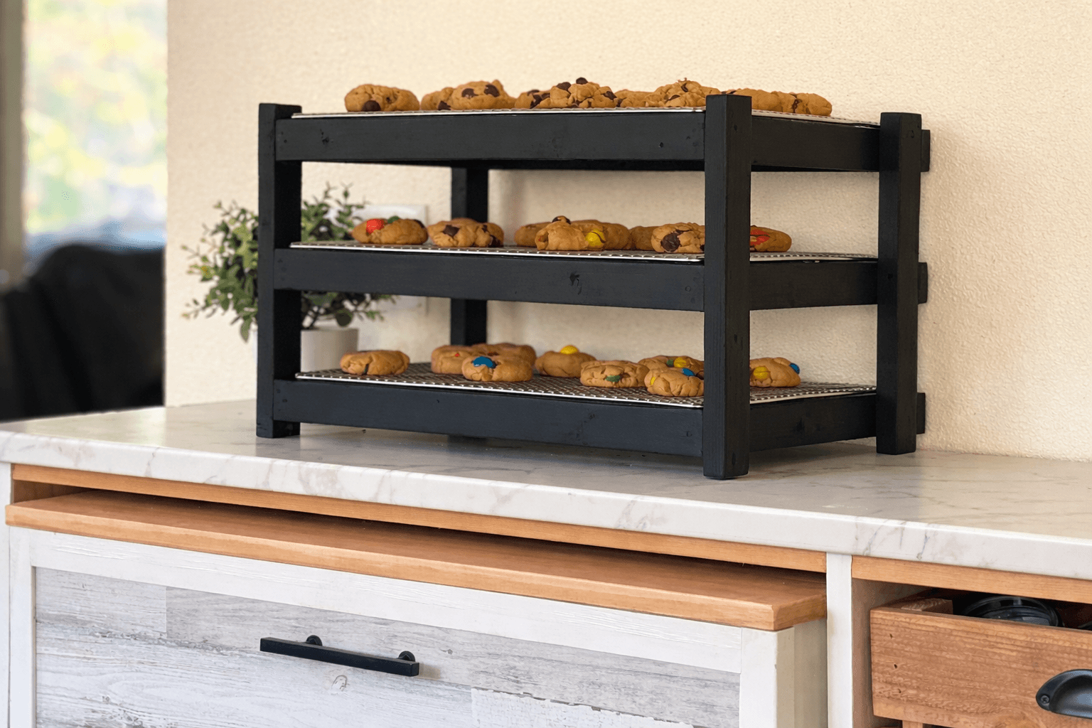 Three-tier countertop cooling rack holding removable baking trays