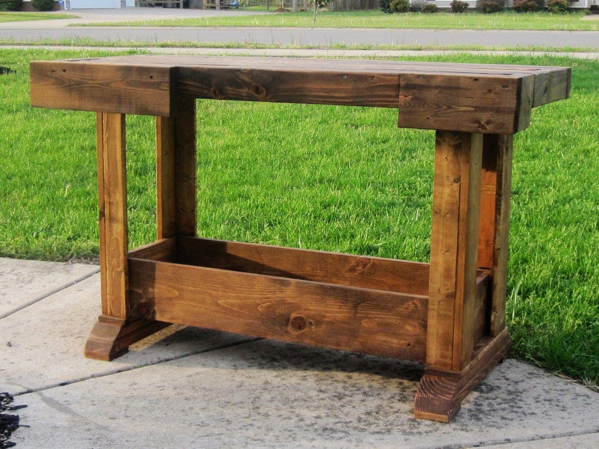 A vintage-styled console table with splayed feet, open-frame legs, and a chunky 2x4 tabletop
