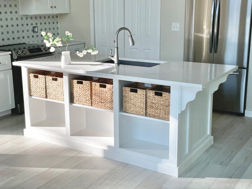 Built-in kitchen island with sink base, trash pull-out, dishwasher panel, and open shelving