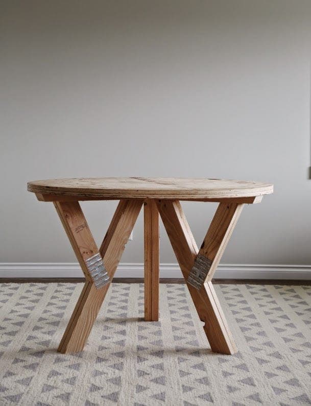 Round table with three angled industrial truss legs