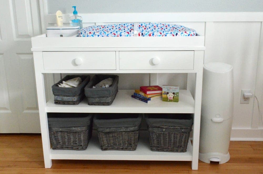 A baby changing table with two drawers and a raised-edge topper