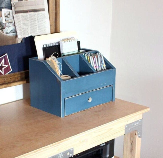 A small wood desk or vanity organizer with angled dividers and one drawer
