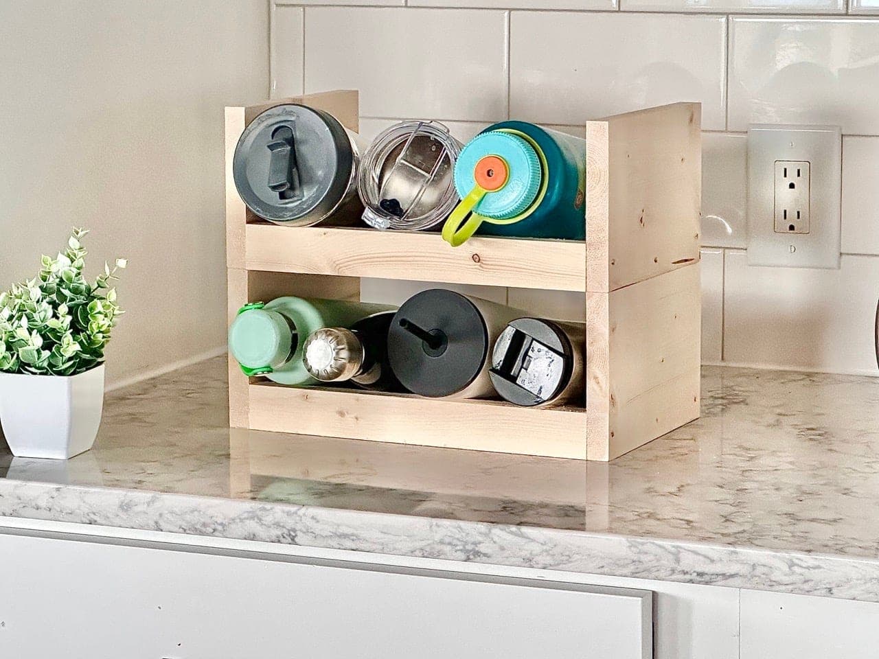 A small stackable wood rack holding water bottles on their sides