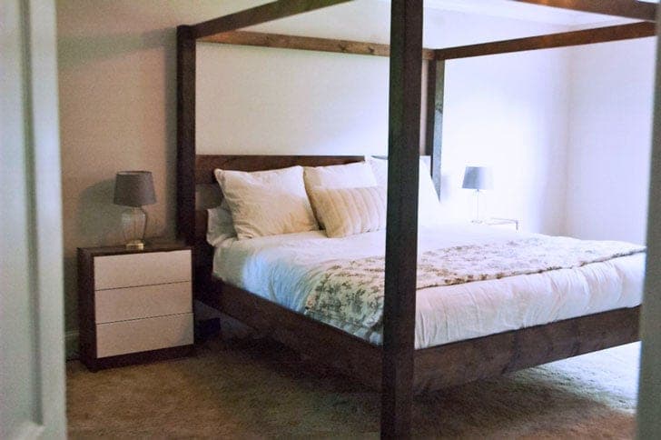 A king-size canopy bed with plain 4x4 posts and an open 2x4 canopy frame