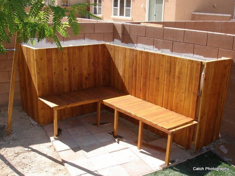 Tall raised planter bed with an integrated bench clad in fence pickets