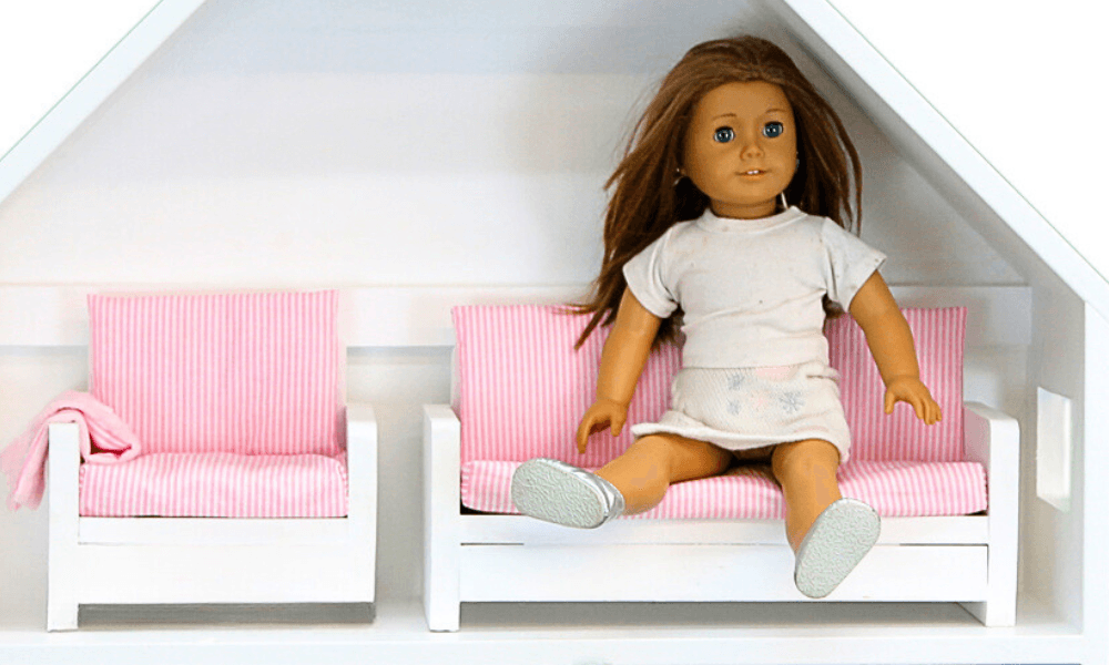 Small wood-framed doll sofa with a sewn cushion
