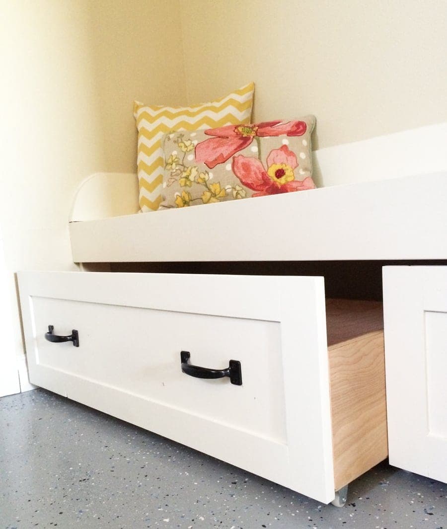 Rolling storage drawers tucked under a mudroom bench