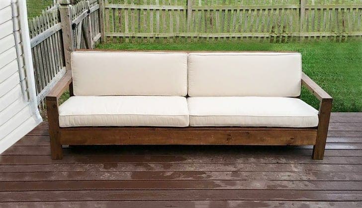 Modern wood outdoor sofa with reclined slat back and deep cushions
